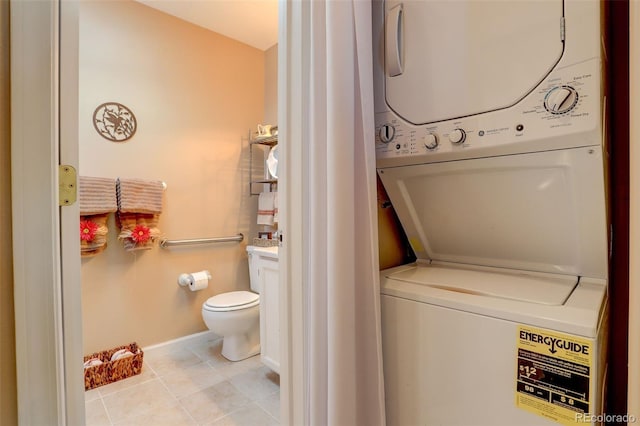 laundry area featuring laundry area, light tile patterned floors, baseboards, and stacked washer / drying machine