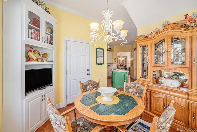 16929 W 63rd Ln, Golden, CO 80403 - dining area with a chandelier, vaulted ceiling, crown molding, and light wood-style floors