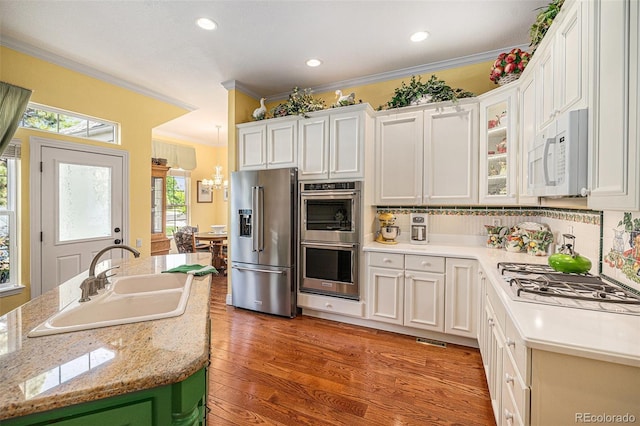 16929 W 63rd Ln, Golden, CO 80403 - kitchen with stainless steel appliances, light countertops, ornamental molding, decorative backsplash, and white cabinets