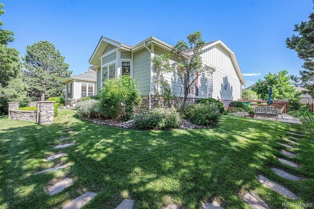 16929 W 63rd Ln, Golden, CO 80403 - view of home's exterior featuring a patio, a yard, and stone siding