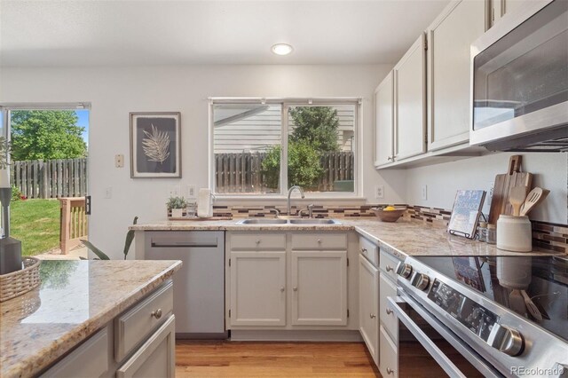 20396 E Berry Pl, Centennial, CO 80015 - kitchen with stainless steel appliances, light wood-style flooring, light stone countertops, recessed lighting, and white cabinets