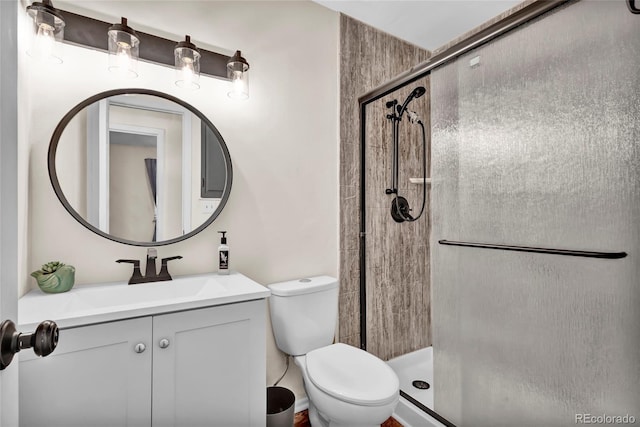 bathroom featuring toilet, an enclosed shower, and vanity