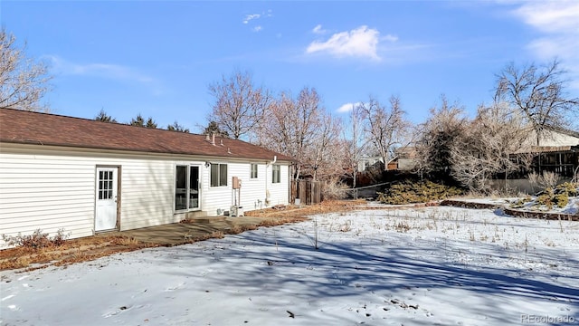 view of snow covered rear of property