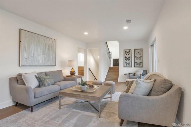 living room with light wood finished floors, recessed lighting, visible vents, stairway, and baseboards