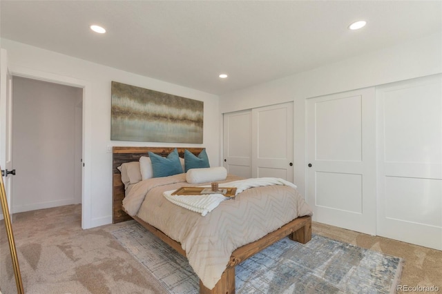 bedroom featuring recessed lighting, carpet flooring, baseboards, and two closets