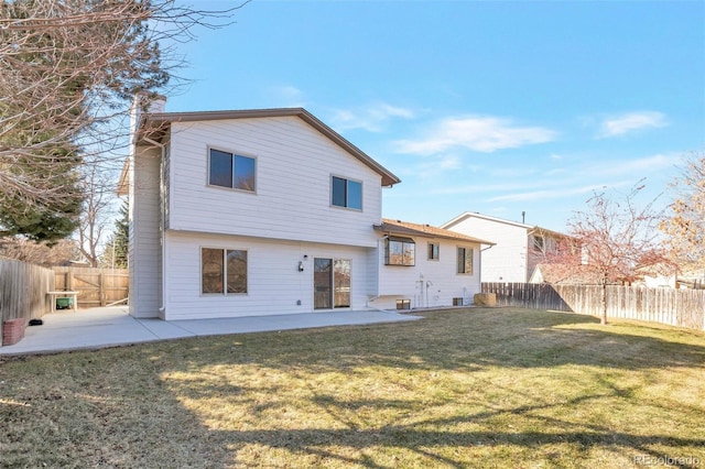 back of house featuring a patio area, a fenced backyard, a chimney, and a yard