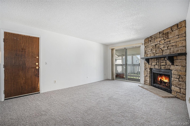 unfurnished living room featuring a stone fireplace, carpet flooring, and a textured ceiling
