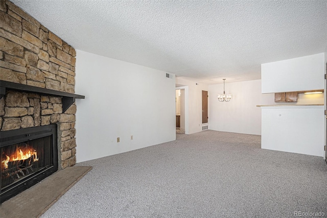unfurnished living room with a fireplace, a chandelier, carpet floors, and a textured ceiling