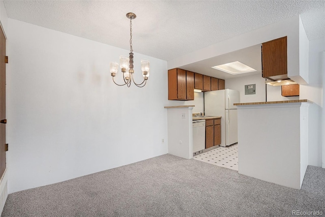 kitchen with white appliances, light colored carpet, a chandelier, a textured ceiling, and brown cabinets