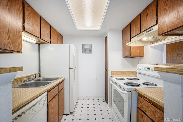 kitchen with white appliances, under cabinet range hood, a sink, light floors, and brown cabinetry