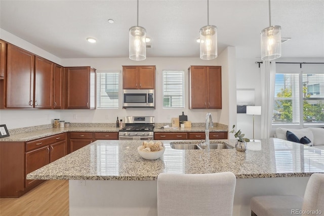 1743 Spring Water Pt, Colorado Springs, CO 80908 - kitchen featuring appliances with stainless steel finishes, a sink, healthy amount of natural light, and a kitchen bar