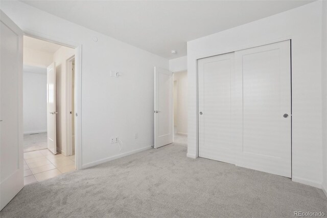1743 Spring Water Pt, Colorado Springs, CO 80908 - unfurnished bedroom featuring carpet flooring, a closet, tile patterned floors, and baseboards