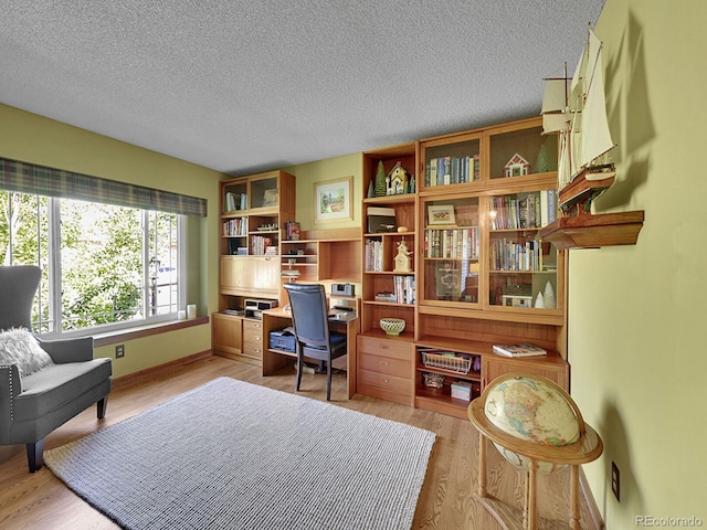 7335 S Milwaukee Way, Centennial, CO 80122 - home office with light wood-type flooring, a textured ceiling, and built in desk