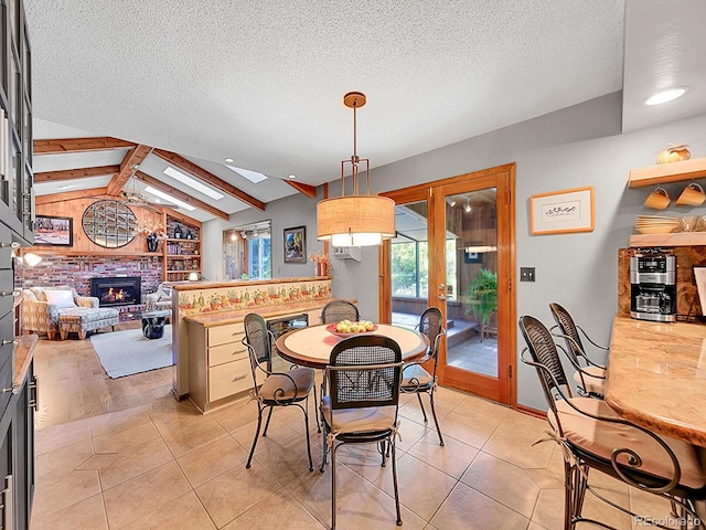 7335 S Milwaukee Way, Centennial, CO 80122 - dining space featuring a skylight, a fireplace, french doors, a textured ceiling, and light tile patterned floors