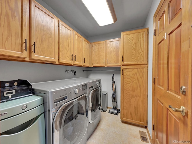 7335 S Milwaukee Way, Centennial, CO 80122 - washroom featuring cabinet space, washer and clothes dryer, and light tile patterned flooring