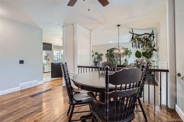 dining room featuring ceiling fan with notable chandelier and hardwood / wood-style flooring