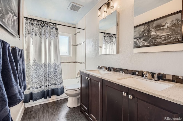 full bathroom featuring shower / tub combo, vanity, and toilet