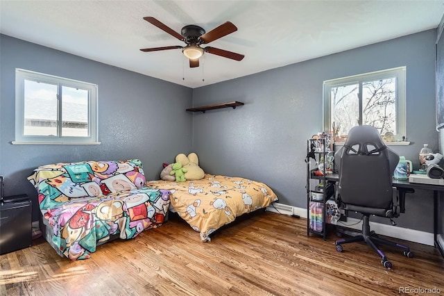 bedroom with multiple windows, ceiling fan, and hardwood / wood-style flooring