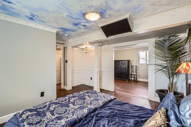 bedroom featuring decorative columns, crown molding, and dark hardwood / wood-style floors