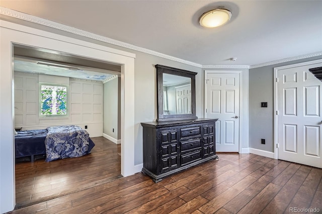 bedroom with dark hardwood / wood-style flooring and ornamental molding