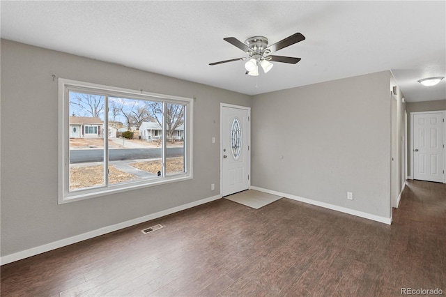 foyer entrance featuring ceiling fan and dark wood-type flooring