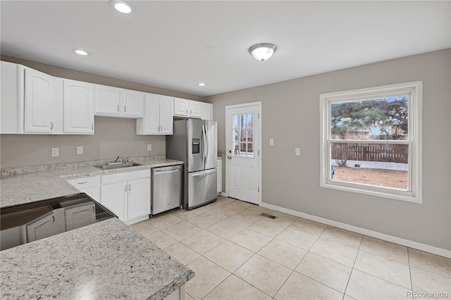 kitchen featuring white cabinets, light tile patterned floors, stainless steel appliances, and sink