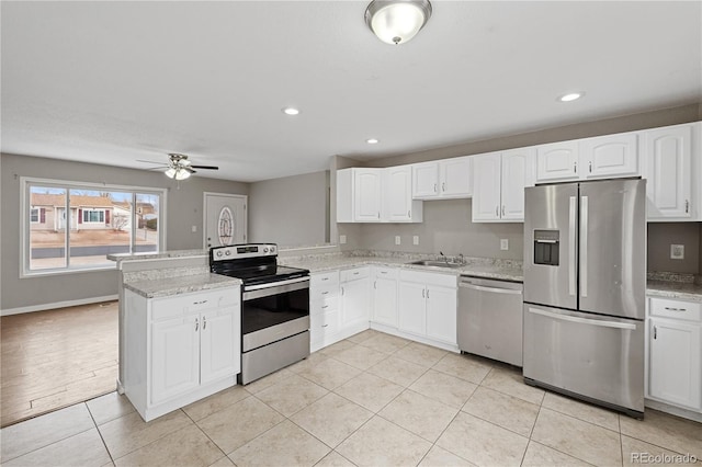 kitchen with white cabinetry, ceiling fan, light stone countertops, and appliances with stainless steel finishes