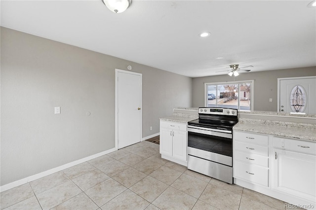 kitchen featuring light stone countertops, stainless steel range with electric stovetop, ceiling fan, white cabinetry, and light tile patterned flooring