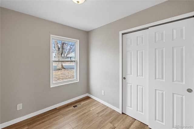 unfurnished bedroom with a closet and light hardwood / wood-style flooring