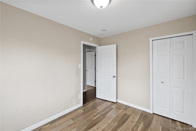 unfurnished bedroom with wood-type flooring and a closet