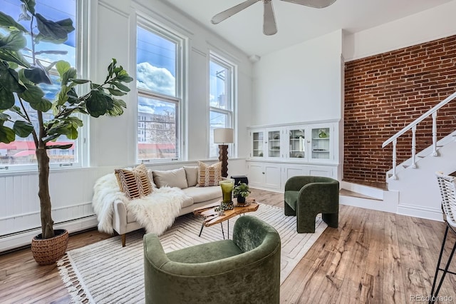 living area featuring stairway, a ceiling fan, and wood finished floors