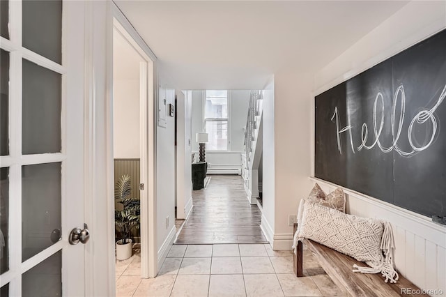 corridor featuring a baseboard heating unit and tile patterned flooring