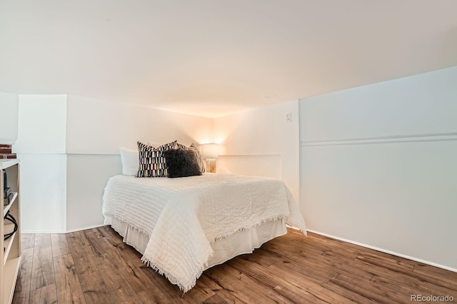 bedroom featuring baseboards and hardwood / wood-style flooring
