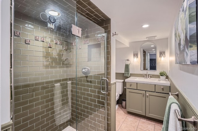 bathroom with vanity, a wainscoted wall, a stall shower, and toilet