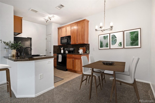 kitchen with pendant lighting, sink, backsplash, black appliances, and kitchen peninsula