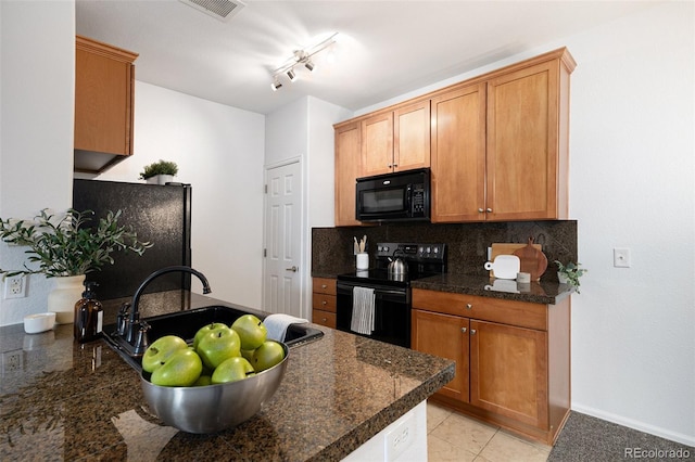 kitchen featuring tasteful backsplash, sink, dark stone counters, and black appliances