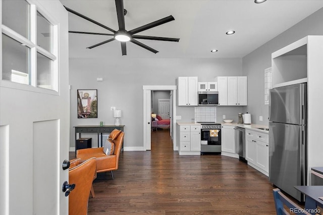 813 E B St, Pueblo, CO 81003 - kitchen featuring dark wood-type flooring, white cabinetry, appliances with stainless steel finishes, and tasteful backsplash