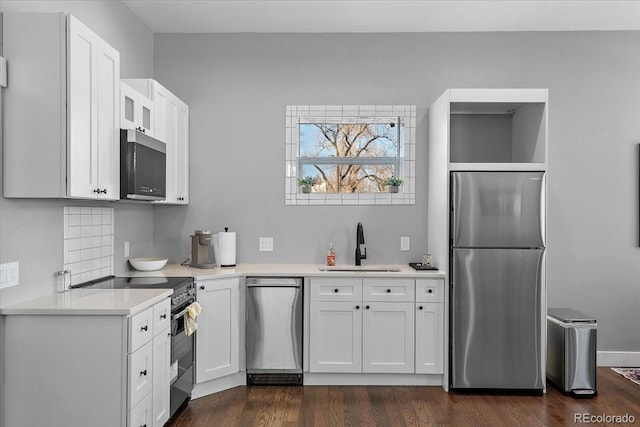 813 E B St, Pueblo, CO 81003 - kitchen with appliances with stainless steel finishes, sink, white cabinets, tasteful backsplash, and dark hardwood / wood-style floors