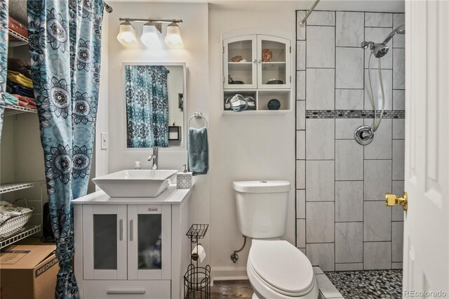 8410 Gray St, Arvada, CO 80003 - bathroom featuring tiled shower, vanity, and toilet