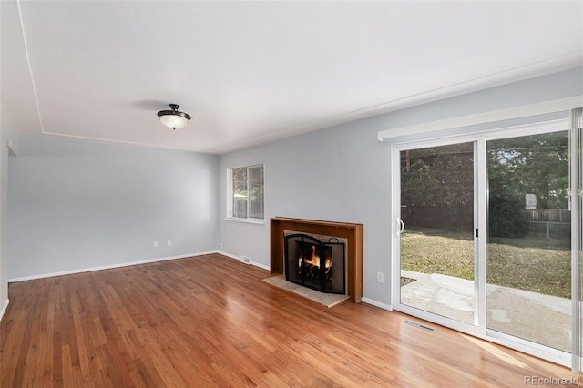 867 S Grape St, Denver, CO 80246 - unfurnished living room with healthy amount of natural light, wood finished floors, and a lit fireplace