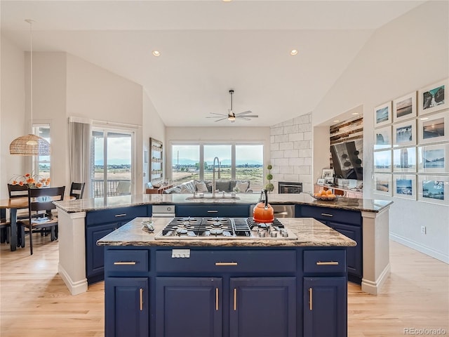 kitchen featuring a kitchen island, lofted ceiling, light hardwood / wood-style floors, and blue cabinets