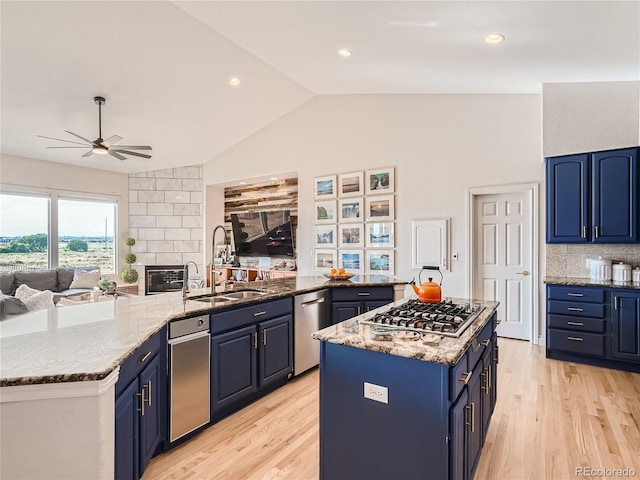 kitchen featuring light hardwood / wood-style flooring, stainless steel appliances, sink, ceiling fan, and blue cabinets