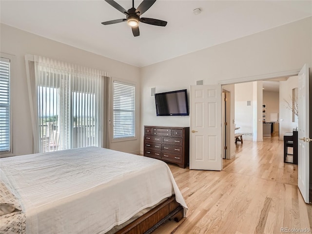 bedroom featuring ceiling fan, light hardwood / wood-style flooring, and multiple windows