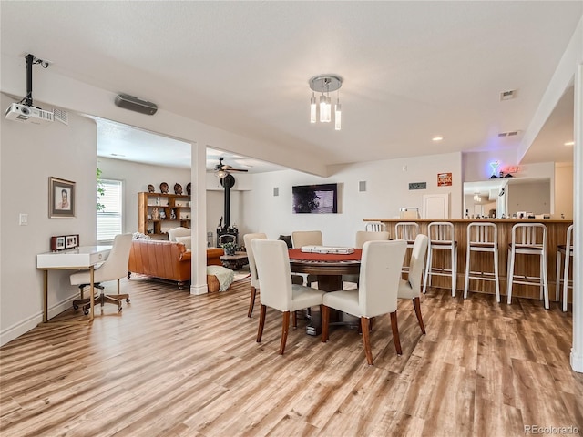 dining area with ceiling fan and light wood-type flooring