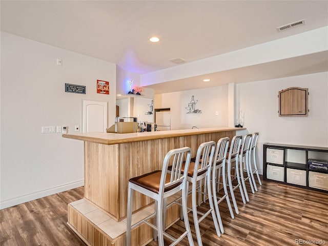 bar featuring hardwood / wood-style floors and white refrigerator