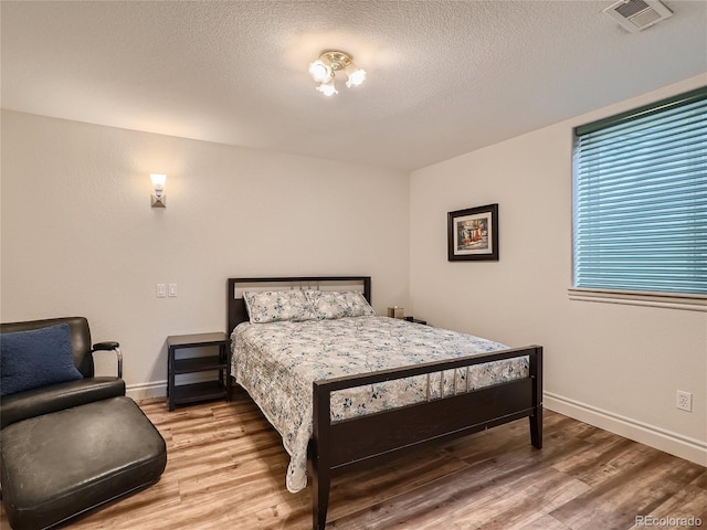 bedroom featuring a textured ceiling and wood-type flooring