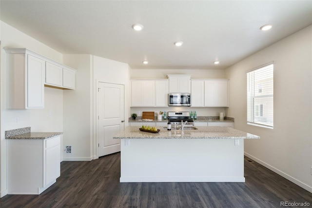 kitchen with white cabinetry, an island with sink, dark wood-type flooring, and appliances with stainless steel finishes