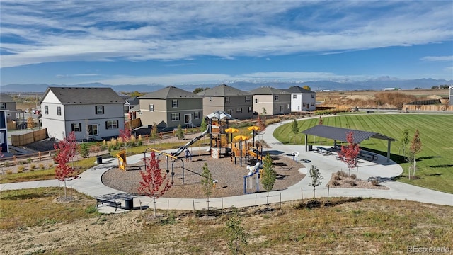 surrounding community featuring a playground and a mountain view