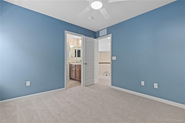 unfurnished bedroom with ceiling fan, ensuite bath, and light carpet
