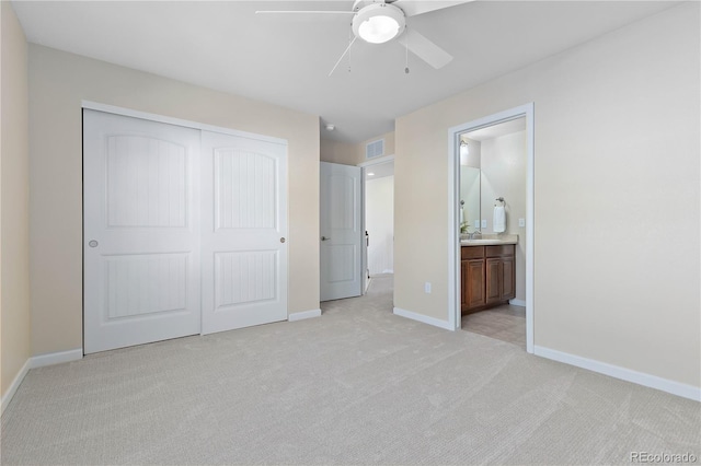 unfurnished bedroom with connected bathroom, light colored carpet, ceiling fan, and a closet